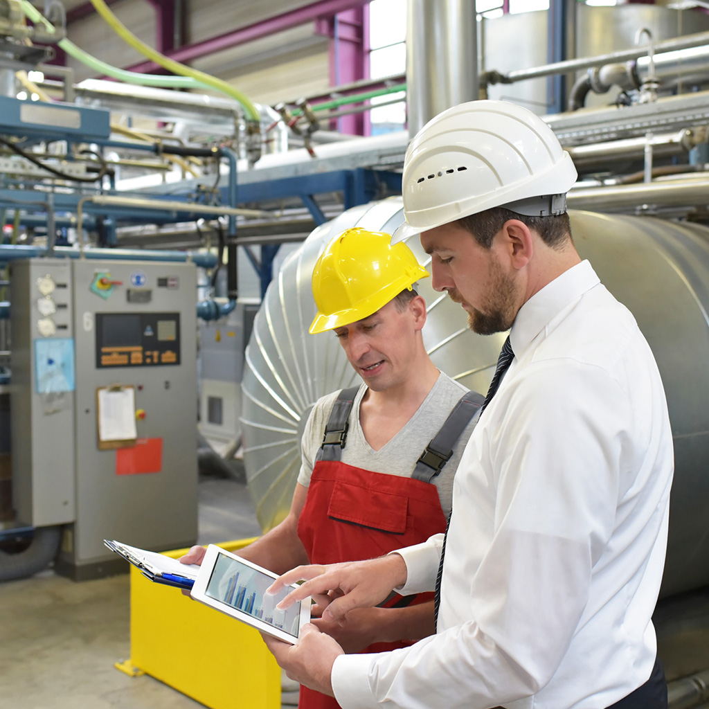 Engineers reviewing risk data in an industrial facility, representing fire and accident insurance for commercial properties