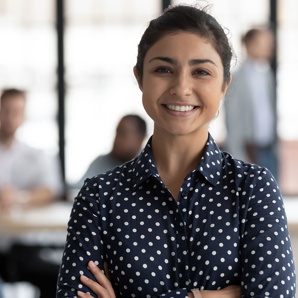 Smiling female professional representing seamless access to cashless medical insurance across the Middle East.