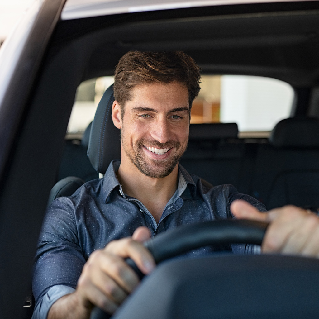 Sukoon’s comprehensive car insurance highlights protection, reliability & customer confidence in the UAE. Man smiling in car.