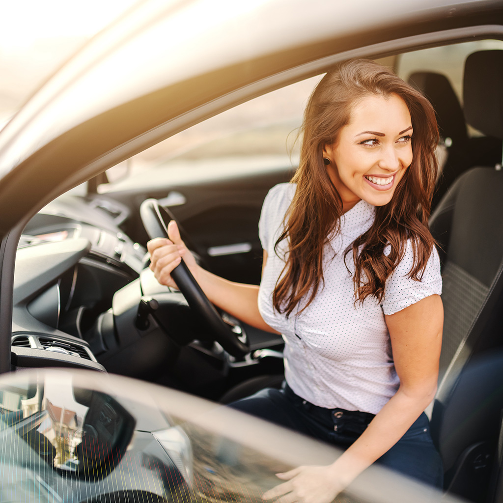 Sukoon's  Third-Party Car Insurance plan protects vehicle owners against third-party liabilities in UAE. Woman in car smiling.